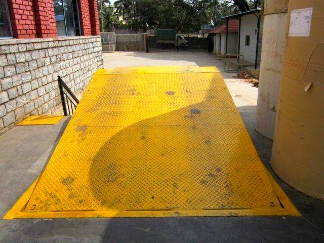 Weather-proof loading bay with height-adjustable ramp